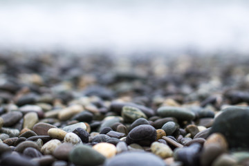 Wet sea pebbles with a wave after a storm with a shallow depth of field