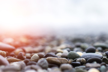 Wet sea pebbles with a wave after a storm with a shallow depth of field