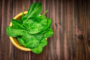 Fresh juicy spinach leaves on a wooden brown table. Natural products, greens, healthy food, vitamins.