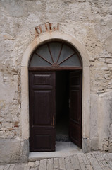 Fototapeta na wymiar Old stone wall with open door, croatian, greek style