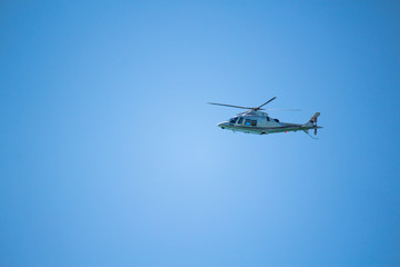 Helicopter flying in the blue sky. Blue background