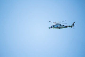 Helicopter flying in the blue sky. Blue background