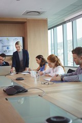 Young businesswoman with team working at conference table
