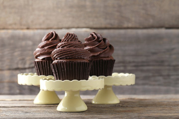 Chocolate cupcakes on cake stand on grey wooden table