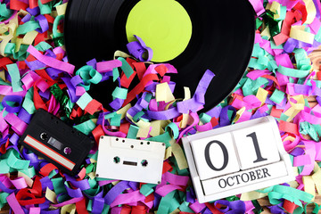Vinyl records with cassette tapes and wooden cubes on colourful confetti