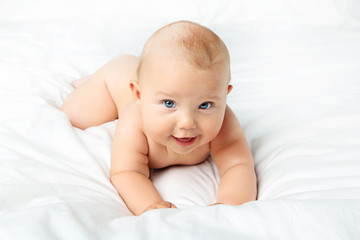 Little newborn baby on white bed