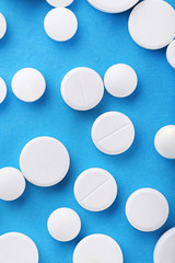 White pills on blue background