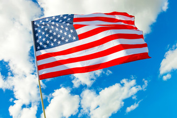 USA flag with clouds on background shot at golden hour