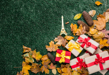Eiffel tower toy and autumn yellow leaves with gifts
