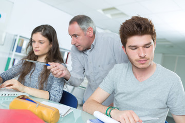 2 students working with teacher