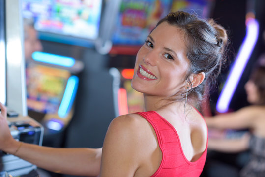 portrait of female gambler sitting at slot machine