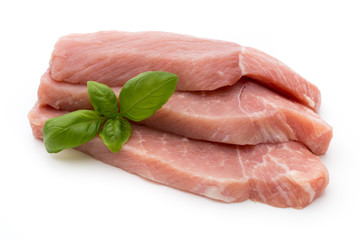 Fresh pork fillet with basil on a white background.