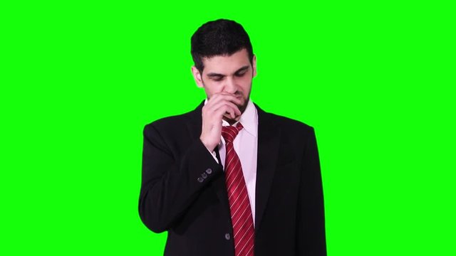 Young Caucasian businessman sneezing in the studio while wearing formal wear and standing against green screen background