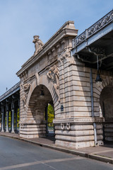 View of pont de Bir-Hakeim (formerly pont de Passy) - a bridge that crosses the Seine River in Paris. Bir-Hakeim bridge is 237 meters long. Central arch decorated with monumental statues. France.