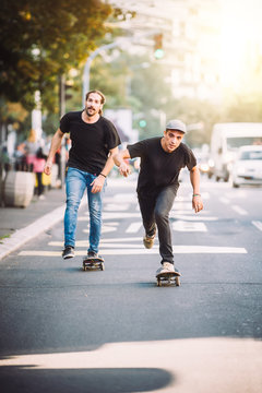 Two skateboarders riding skateboard slope on the city streets