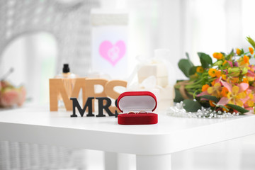 Rings in box with decorations for lesbian wedding on table in the room