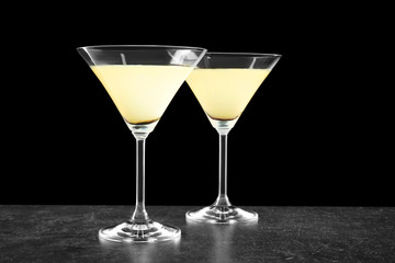 Glasses of lemon drop martini on black background