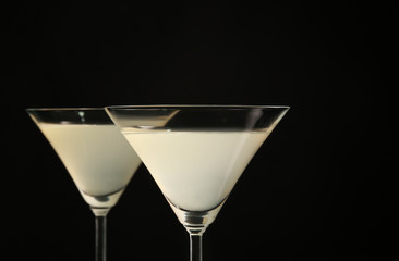 Glasses of lemon drop martini on black background