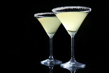 Glasses of lemon drop martini on black background