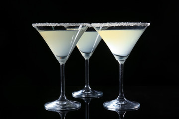 Glasses of lemon drop martini on black background