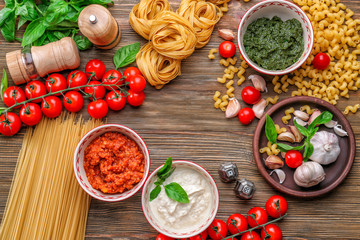 Composition with pesto, bolognese and white sauces for pasta in bowls on table