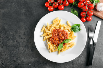 Plate of delicious pasta with bolognese sauce on table
