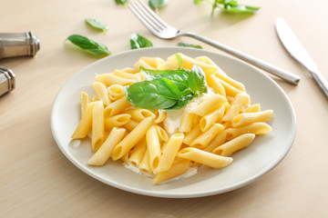 Plate of delicious pasta with white sauce on table