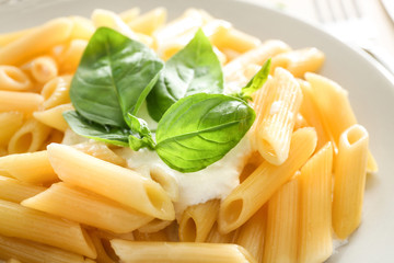 Delicious pasta with white sauce on plate, closeup