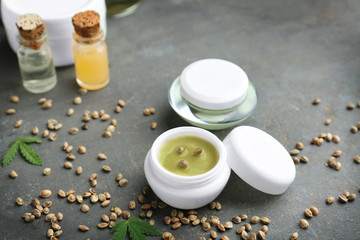 Hemp cosmetic products and seeds on dark background