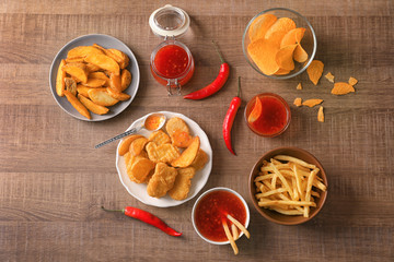 Fast food snacks with chili sauce on wooden background