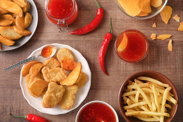 Fast food snacks with chili sauce on wooden background