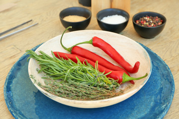 Fresh vegetables and herbs in bowl on blue coaster