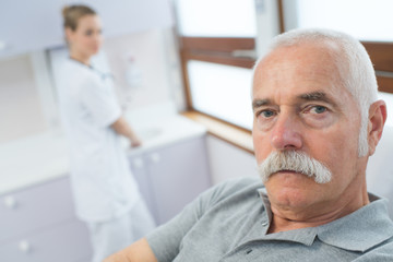 Fototapeta premium nurse near elderly male patient in hospital