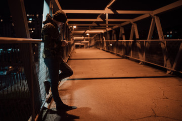 Man leaned on the fence using his cellphone