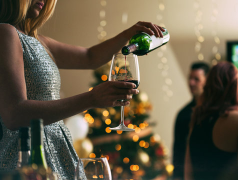 NYE: Woman At Party Filling Up Wine Glass