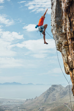 Rock climber falling whilst climbing a mountain cliff