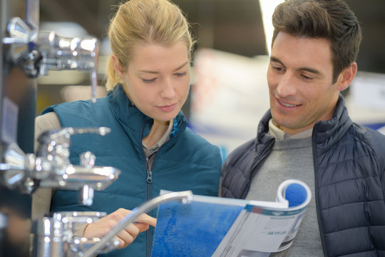 couple looking in catalogue for faucets