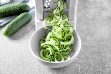 Spiral vegetable slicer with cucumber spaghetti on table