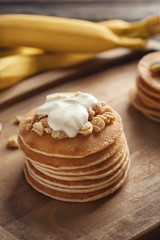 Yummy banana pancakes on wooden board