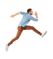 Young man in casual clothes running on white background