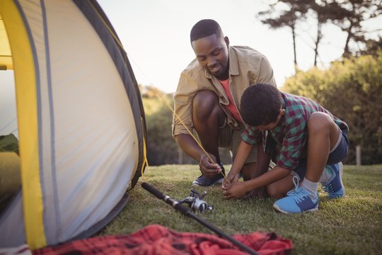 Father and son are setting up tent in park - Powered by Adobe