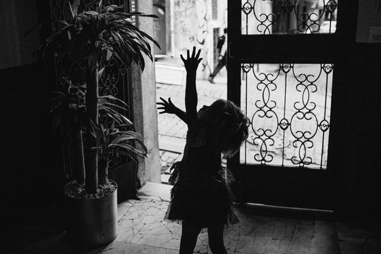 Silhouette of little girl waving her arms in the air on her way outside.
