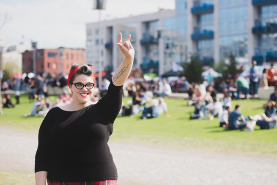 Woman making rock sign with hand at outdoor festival