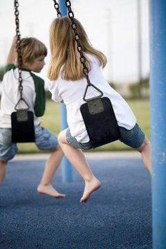 Back View Of Boy and Girl on Swings