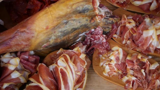 Assorted deli meats, ham, salami, bacon on the wood tray