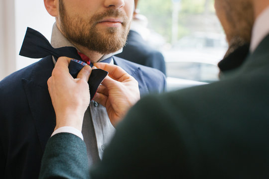 Men's Fashion - Close Up of Man Helping Friend to Tie Bow Tie