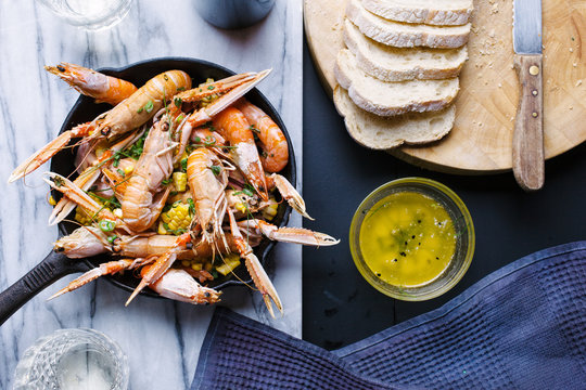 Roasted seafood in a skillet with corn and garlic butter.