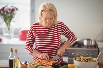 Senior woman chopping vegetables