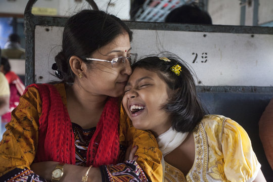 Woman kisses her daughter in local train travel