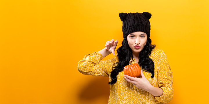 Young woman holding a pumpkin in halloween theme